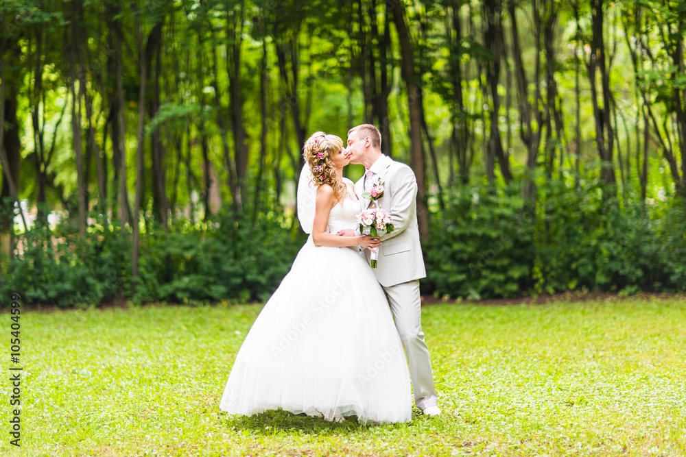 Young wedding couple enjoying romantic moments outside on a summer park Young wedding couple enjoying romantic moments outside on a summer park