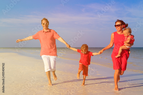 family with two kids having fun on tropical beach