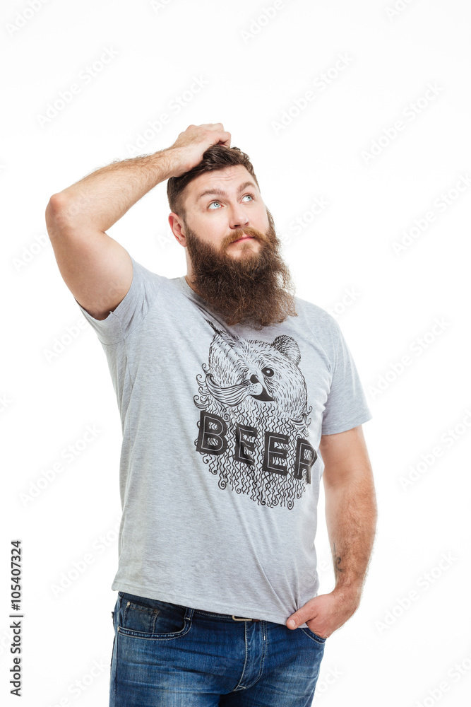 Pensive handsome bearded man scratching his head and thinking Pensive handsome bearded man scratching his head and thinking