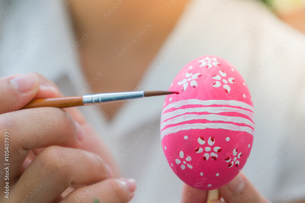Woman hand decorating Easter eggs Woman hand decorating Easter eggs
