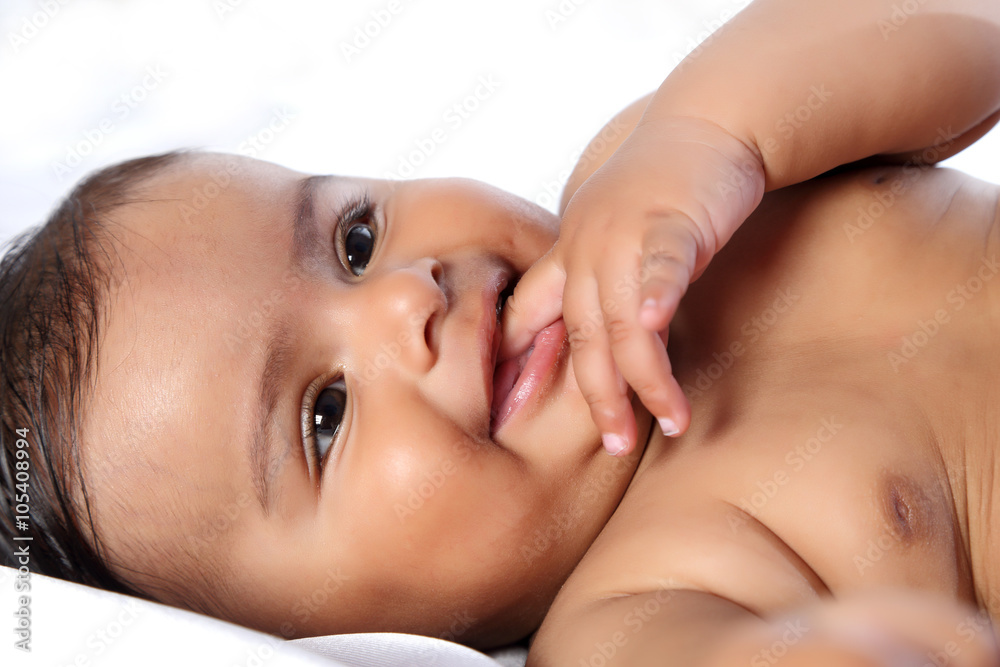Portrait of a beautiful little baby. Close-up. Little baby smiling and chewing finger. Portrait of a beautiful little baby. Close-up. Little baby smiling and chewing finger.