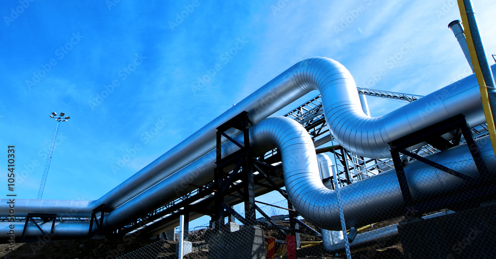 Obraz premium Industrial zone, Steel pipelines and valves against blue sky