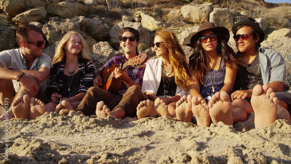 Group of young people at beach with feet in sand