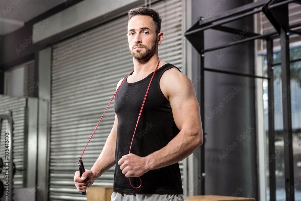 Muscular man holding rope around his neck Muscular man holding rope around his neck