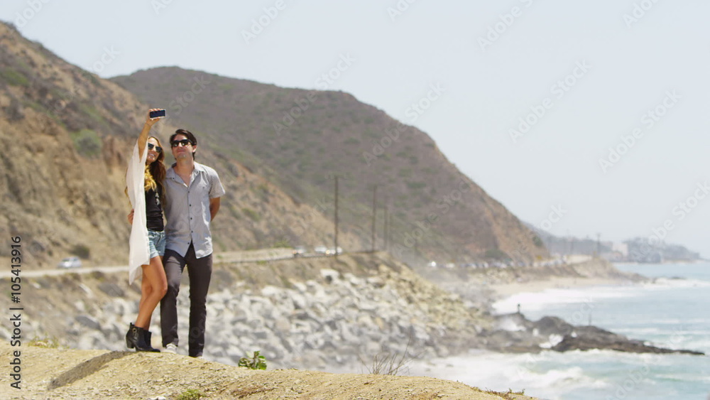 Couple taking a picture on the coast Couple taking a picture on the coast