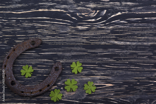 Fabric green clover leaves with horseshoe on wooden background. 