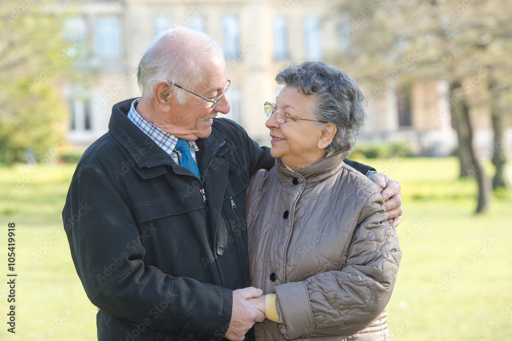 elderly couple holding hands