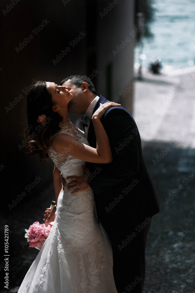Naklejka premium sweet romantic beautiful happy couple kissing at stone streets o