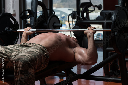 Bodybuilder Exercising Chest With Barbell