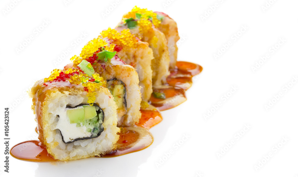 Crumch sushi roll with cheese and avocado decorated with green onion and spice sauces over white background Crumch sushi roll with cheese and avocado decorated with green onion and spice sauces over white background