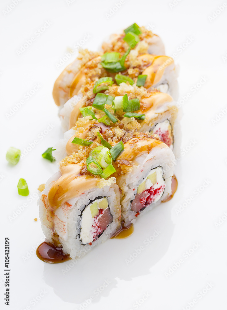 Sushi with shrimp avocado salmon and cheese strewed with green onion. Crunch Roll. With delicious sauces. Over white background.