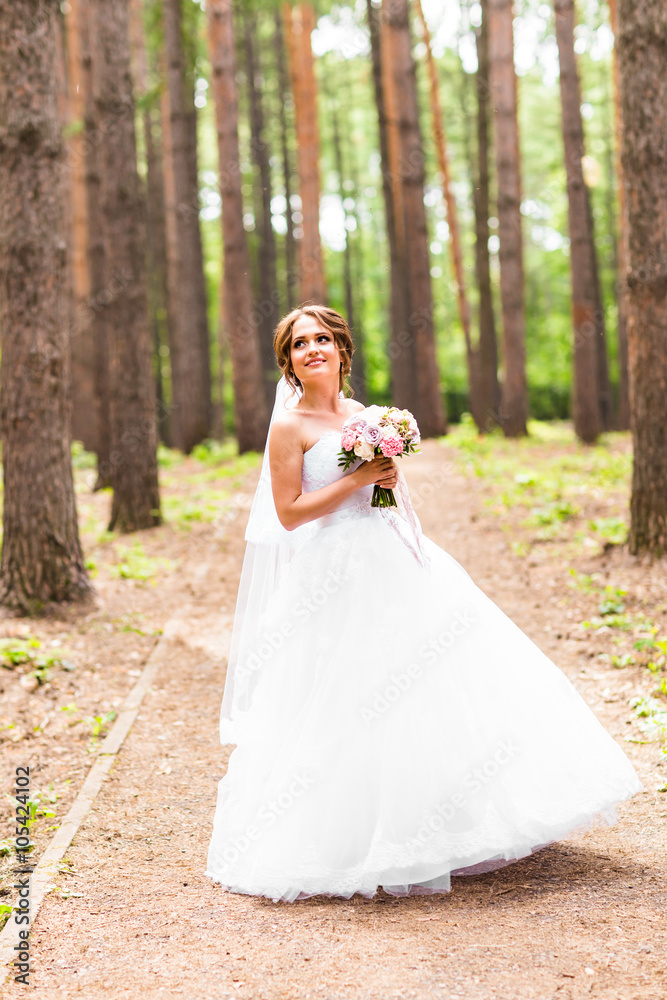 Beautiful bride with bouquet of flowers outdoor