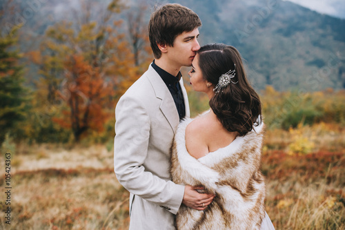 happy newly married couple posing in the mountains