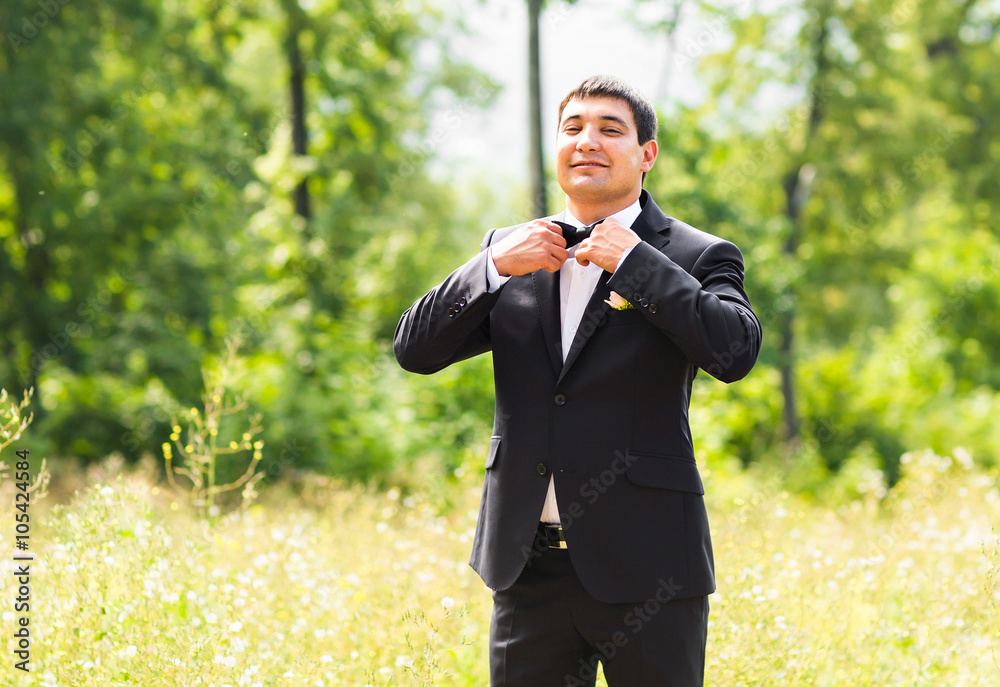 portrait of handsome stylish groom in black classic suit outdoors portrait of handsome stylish groom in black classic suit outdoors