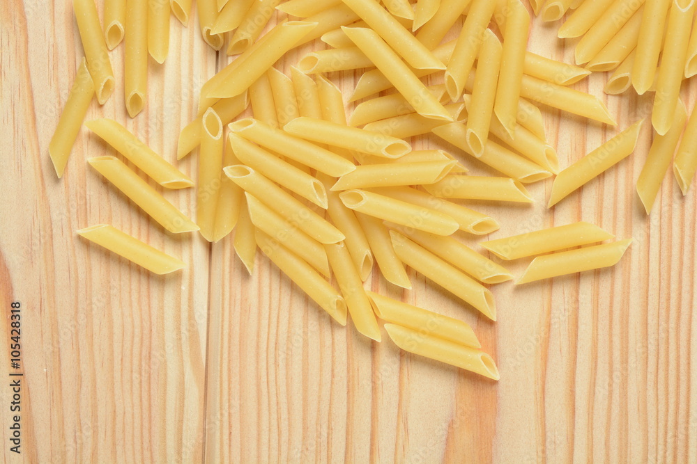 Pasta penne cruda sobre un fondo de madera Pasta penne cruda sobre un fondo de madera