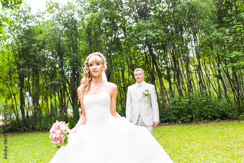 Young wedding couple enjoying romantic moments outside on a summer park Young wedding couple enjoying romantic moments outside on a summer park
