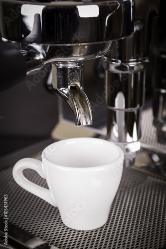 cup of espresso poured from a espresso machine 