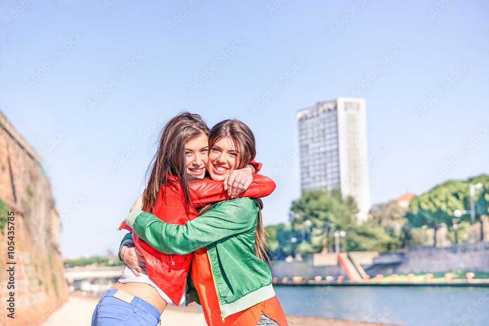 Best hipster friends hugging each others with skyscraper in back