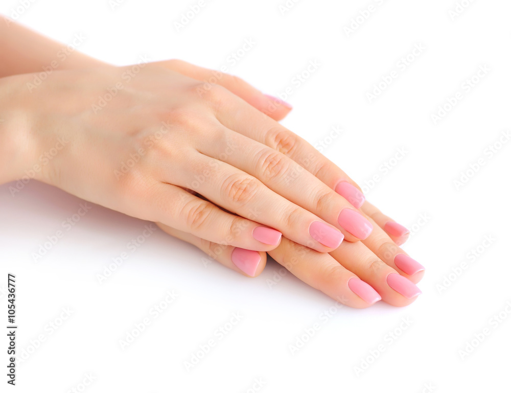 Closeup of hands of a young woman with pink manicure on nails against white background