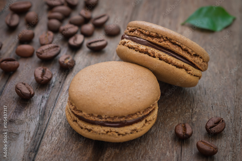 French macaroons and coffee beans on wooden table French macaroons and coffee beans on wooden table