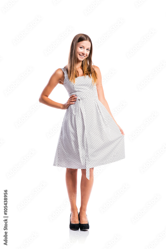 Girl in black-and-white dotted dress, heels, studio shot Girl in black-and-white dotted dress, heels, studio shot