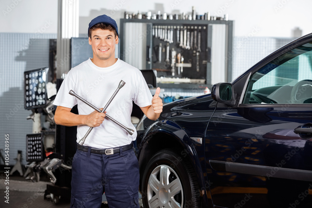 Mechanic Gesturing Thumbs Up While Holding Rim Wrench Mechanic Gesturing Thumbs Up While Holding Rim Wrench