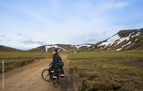 Biker rides on road at summer evening in Iceland. Travel and sport picture