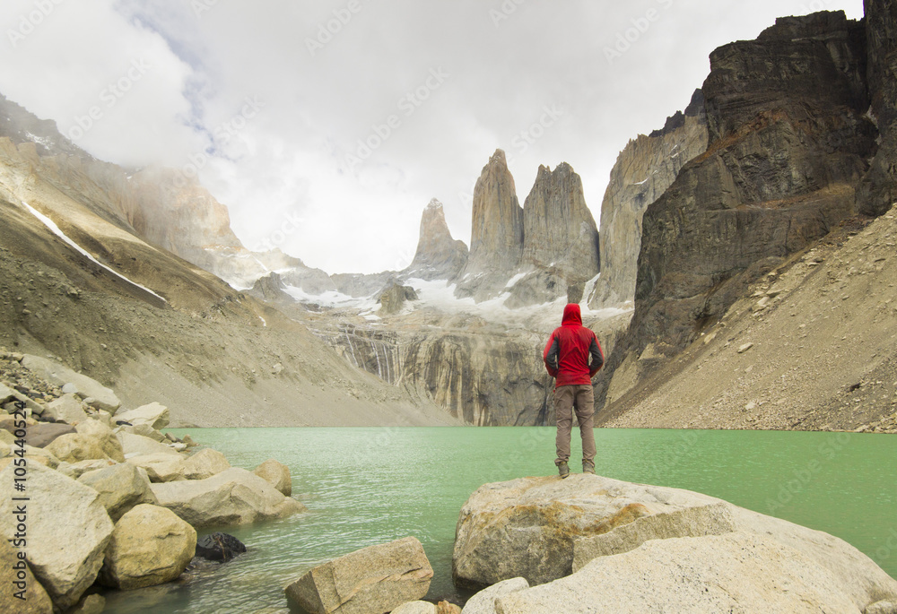man standing near lake in patagonia, torres del paine