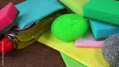 Container with liquid for glass, wipes, colorful sponges for washing, blue cleaning brush
