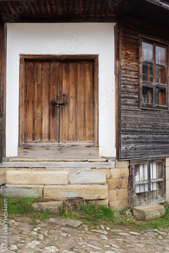  Detail of vintage wooden door and windows of the old wood house. On the background of white walls