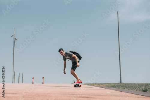 Skateboarder is flying down the wide road