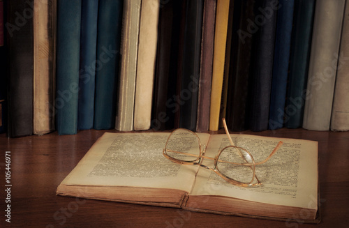 Открытые книги на столе, очки и кружка