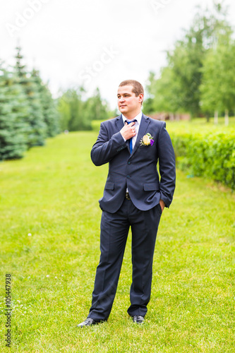 Groom in suit on the nature. Male portrait outdoors. Handsome guy outdoors 