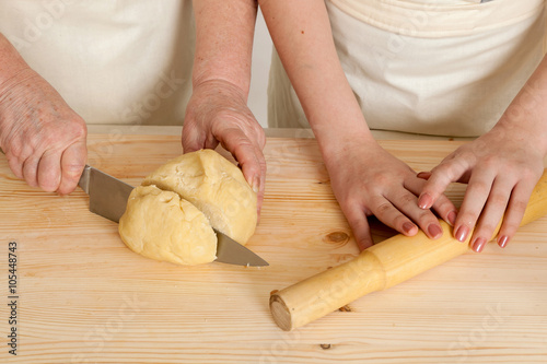 hands of the grandmother and hand of the granddaughter knife dou photo