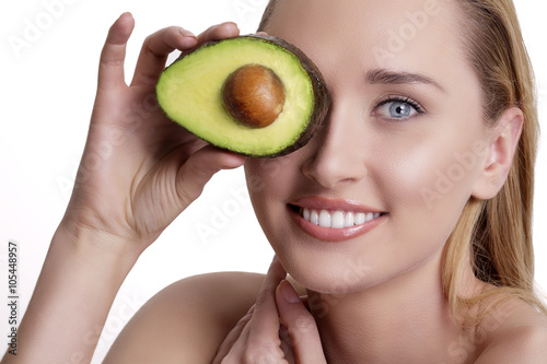 young happy woman showing an avocado