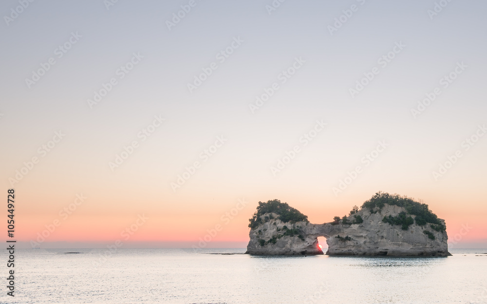 Scene of a particular island with a hole in the middle and sunse
