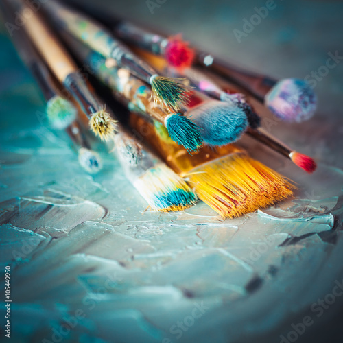 Paintbrushes on artist canvas covered with oil paints. Retro sty