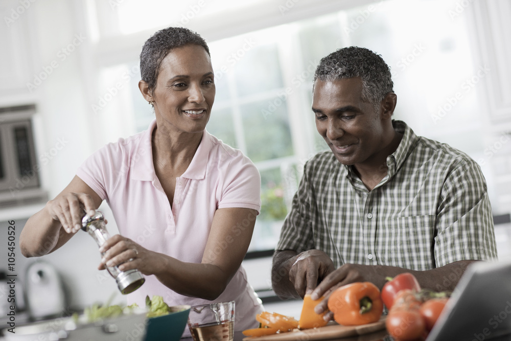 A couple in the kitchen of their home, side by side, A couple in the kitchen of their home, side by side,
