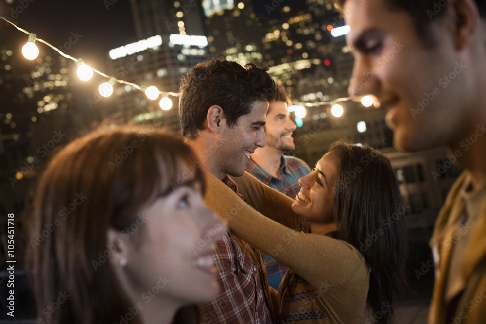 A group of men and women at a rooftop party, A group of men and women at a rooftop party,