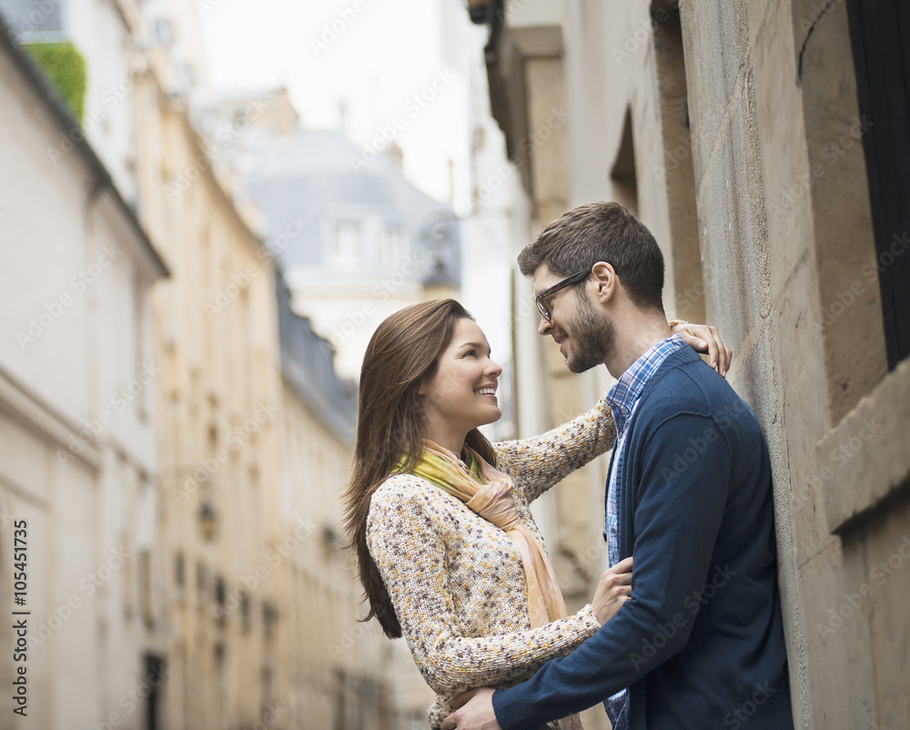A couple standing gazing at each other, in a narrow street in a city, A couple standing gazing at each other, in a narrow street in a city,