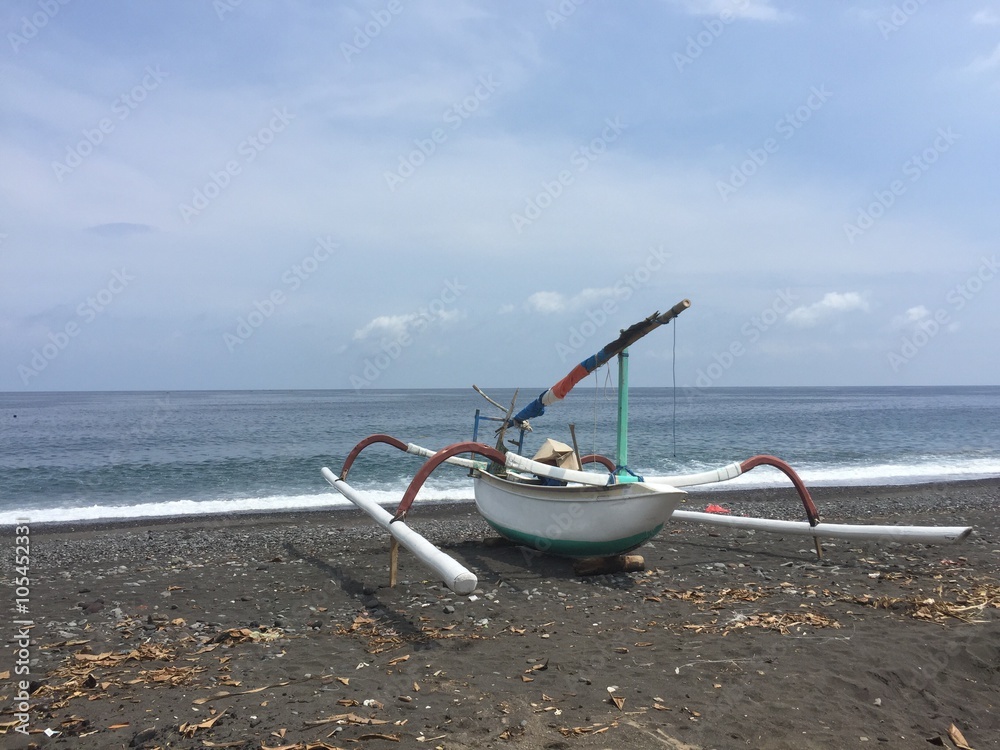 Traditional white boat in Amed, Bali, on black sand beach Traditional white boat in Amed, Bali, on black sand beach