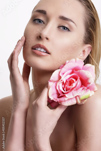 Beauty blonde young woman showing a fresh flower on white