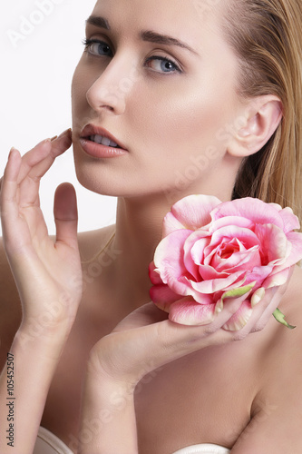 Beauty blonde young woman showing a fresh flower on white