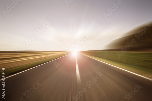 Auf einer Straße der Sonne entgegen mit Geschwindigkeit