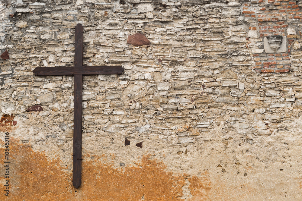 Wooden cross on stone wall