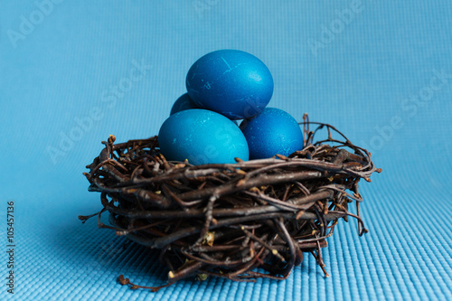 Blue Easter eggs in the nest on blue background photo