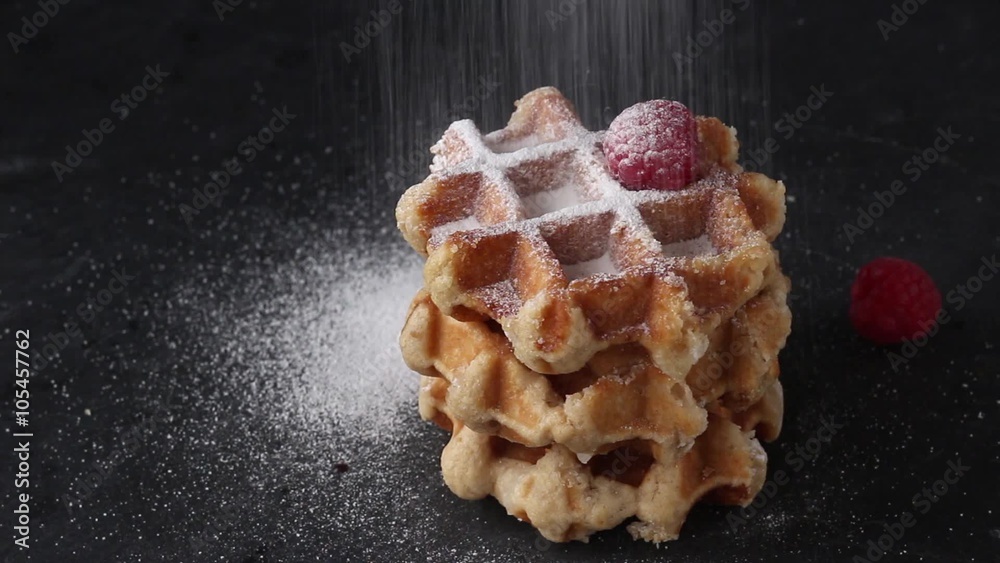 Belgian waffles with raspberries and sugar powder over rusty surface