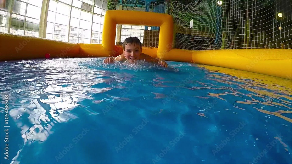 Happy Teen boy slides on the stomach on the surface of water