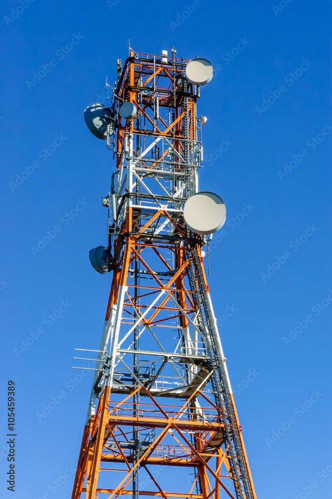 Radio/Telecommunication Tower in white and orange with blue sky