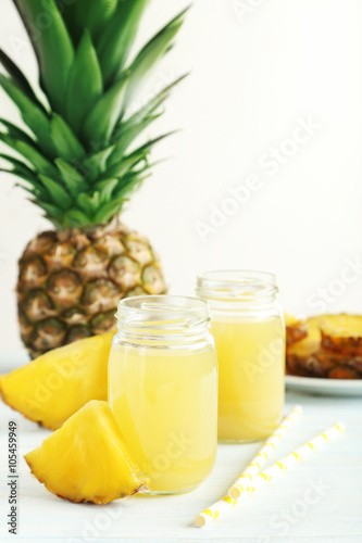 Bottles of pineapple juice on a white wooden table